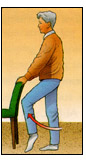 Post operative male patient standing behind and holding onto a chair performing Standing Knee Raises