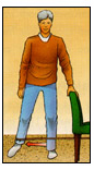 Post operative male patient standing aside and holding onto a chair performing Resistive Hip Abduction exercises